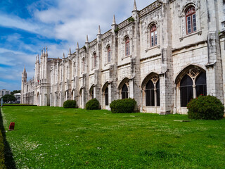 Fototapeta premium Scenic view of Mosteiro or monastery dos Jeronimos in city of Lisbon, Portugal. Displaying Manueline architecture surrounded by idyllic Praca do Imperio gardens. Tourist travel destination