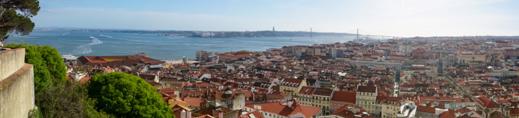 Panoramic aerial view over the city of Lisbon seen from San Jorge castle, Portugal, Europe. Looking at the beautiful red rooftops of the old town centre. Travel destination in summer. Urban landscape
