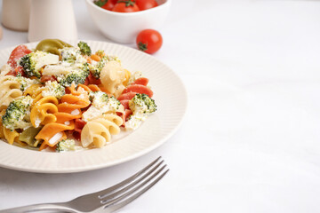 Delicious fusilli pasta with broccoli and cheese in plate on light background