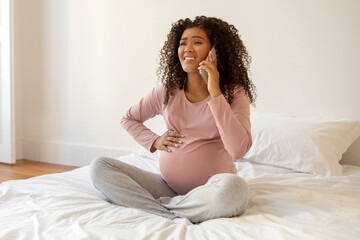 Pregnancy Cramps. Worried Black Pregnant Woman Touching Belly And Calling Doctor