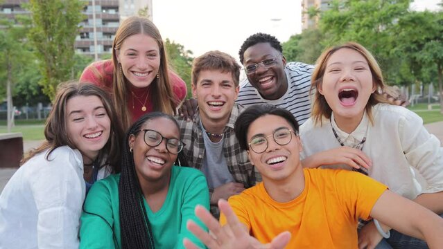 Big group of young adult real people greeting, smiling and having fun at vacations. Happy friends laughing. University teenage students waving hands on a social gathering Multiracial teenagers meeting
