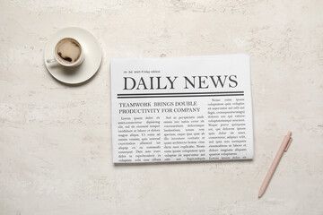 Newspaper with cup of coffee and pen on white background. Top view