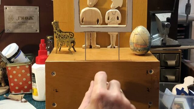 master turns the handle of the automato, Spectators, art critics examine the painting, wooden funny mechanical toy panorama up