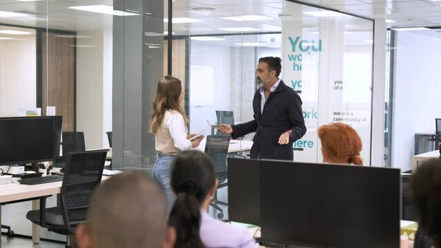 Businessman scolding female employee in creative office