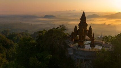Beautiful sunrise with pagoda on the top of cliff, morning mist at Khao Na Nai Luang Dharma Park,...