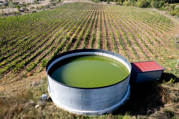 Vineyards and industrial water tank shot from above.