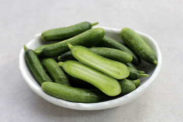 Fresh mini cucumbers in bowl