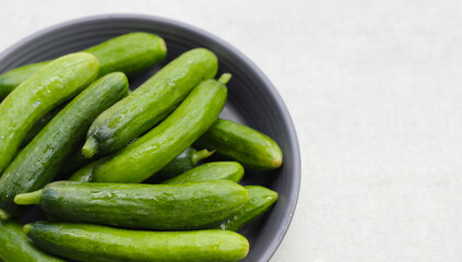 Fresh mini cucumbers in bowl