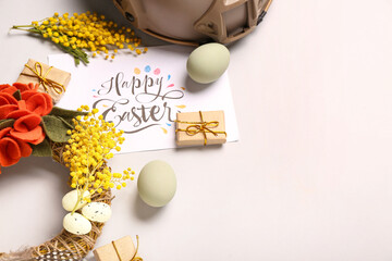 Composition with greeting card, beautiful Easter decor and military helmet on light background
