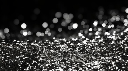 Silver glitter sparkles on a black background with a smooth transition