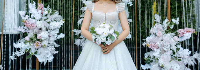 Brides holding her bouquet from roses