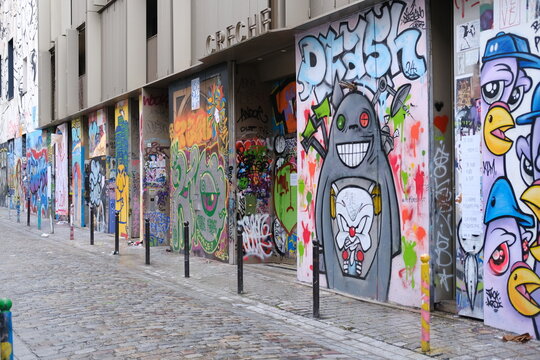 Some street art graffiti on the facades of the Denoyez street. Paris, France - March 12, 2024.