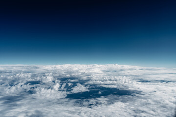 Above the clouds, view out of plane window, blue sky