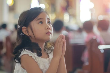 Fotobehang cute small girl praying in the church and Jesus giving blessing, cinematic effect, studios light.  © JovialFox
