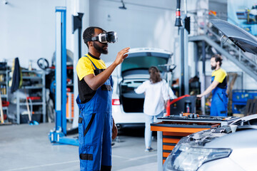 Repairman in auto repair shop using virtual reality to visualize car exhaust system in order to fix...