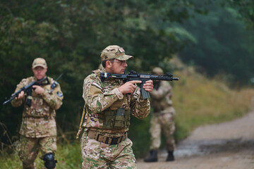 Fototapeta premium A disciplined and specialized military unit, donned in camouflage, strategically patrolling and maintaining control in a high-stakes environment, showcasing their precision, unity, and readiness for