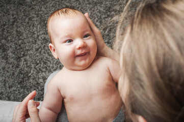 Seborrheic dermatitis in newborns. Newborn 2 month old baby with mom in her arms close up