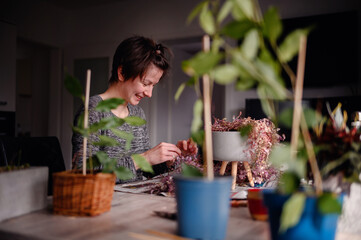 A woman's joyful laughter fills the room as she enjoys a relaxing session of indoor gardening,...