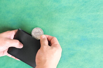 Human hand holding black wallet with bitcoin coin inside. Cryptocurrency use for payment concept.