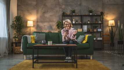 mature woman caucasian female hold credit card online shopping at home