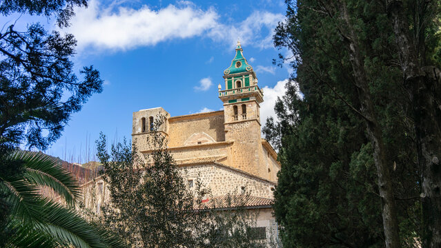 Carthusian Monastery of Valldemossa Peeking Through Verdant Trees in Mallorca
