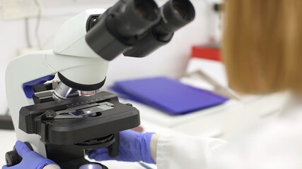 Closeup of microscope used by a woman