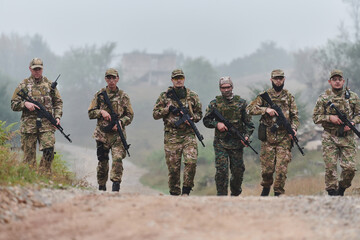 Fototapeta premium A disciplined and specialized military unit, donned in camouflage, strategically patrolling and maintaining control in a high-stakes environment, showcasing their precision, unity, and readiness for