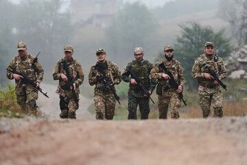 Fototapeta premium A disciplined and specialized military unit, donned in camouflage, strategically patrolling and maintaining control in a high-stakes environment, showcasing their precision, unity, and readiness for