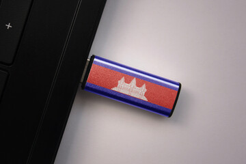 usb flash drive in notebook computer with the national flag of cambodia on gray background.