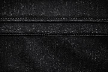 Naklejka premium Close-up of white thread stitching on black denim fabric