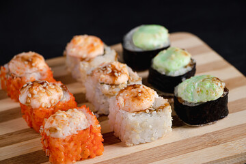 Set of sushi rolls on bamboo serving tray. Uramaki and futomaki roll