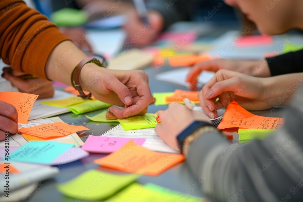 Poster Individuals engaging in a brainstorming session with colorful sticky notes on a table