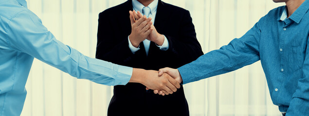 Corporate attorney applaud as business people seal a successful deal or agreement with handshake, celebrating mutually beneficial acquisition. Business handshaking concept. Panorama Rigid © InfiniteFlow