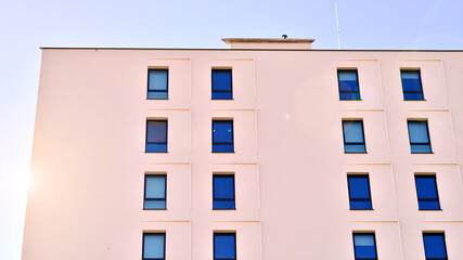 View of a white modern apartment building. Perfect symmetry with blue sky. Geometric architecture detail modern concrete structure building. Abstract concrete architecture. 