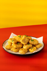 Delicious golden chicken nuggets on a plate on the table. Fast food, menu.
