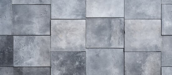 A close up of a rectangular grey tile wall made of composite material. The flooring features a symmetrical pattern with tints and shades, creating parallel lines