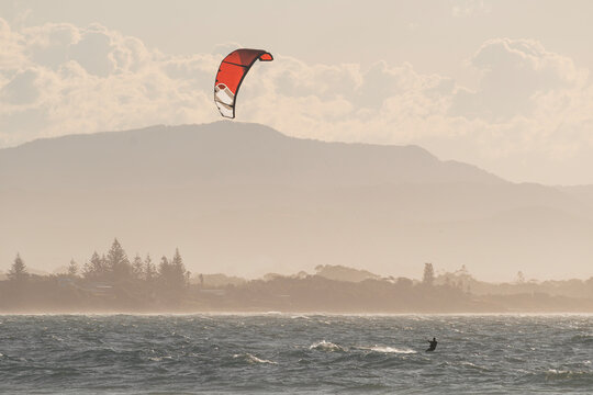 Senior man kitesurfing on a Byron Bay beach during sunset. Australia