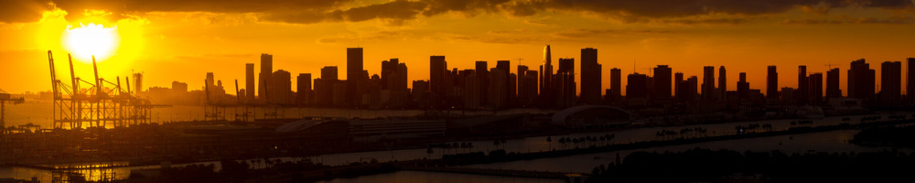 Miami downtown skyline silhouette against orange sunset sky 