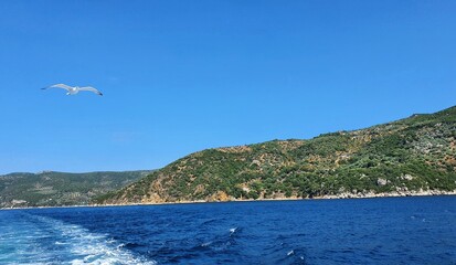 fragment greckiego wybrzeża widziany podczas podróży statkiem. Piękne błękitne niebo.