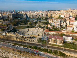 Obraz premium Aerial view of ruins of ancient Roman amphitheater on background with Tarragona cityscape, Spain