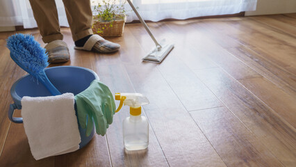 掃除道具｜ワイパーで床掃除する人