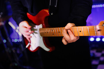 Guitarist plays the electric guitar during the rock concert.