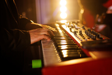 A musician plays modern piano keyboards during a concert performance. - obrazy, fototapety, plakaty