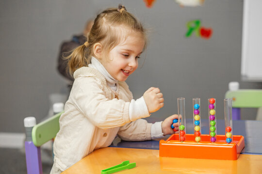 Joyful Toddler Girl Playing with Learning Bead Toy