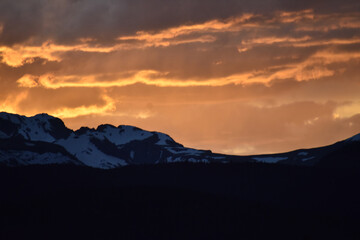 Sun Glowing Through the Clouds at Sunset Over the Rocky Mountains