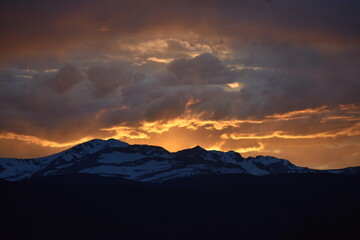 Sun Glowing Through the Clouds at Sunset Over the Rocky Mountains