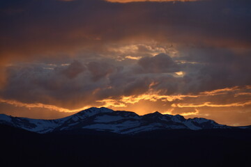 Sun Glowing Through the Clouds at Sunset Over the Rocky Mountains