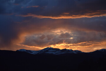 Sun Glowing Through the Clouds at Sunset Over the Rocky Mountains