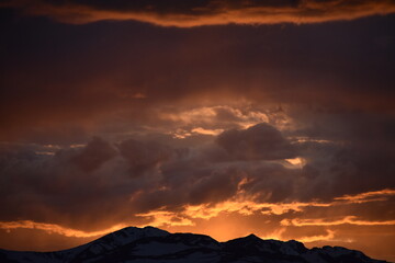Sun Glowing Through the Clouds at Sunset Over the Rocky Mountains