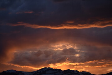 Fototapeta premium Sun Glowing Through the Clouds at Sunset Over the Rocky Mountains